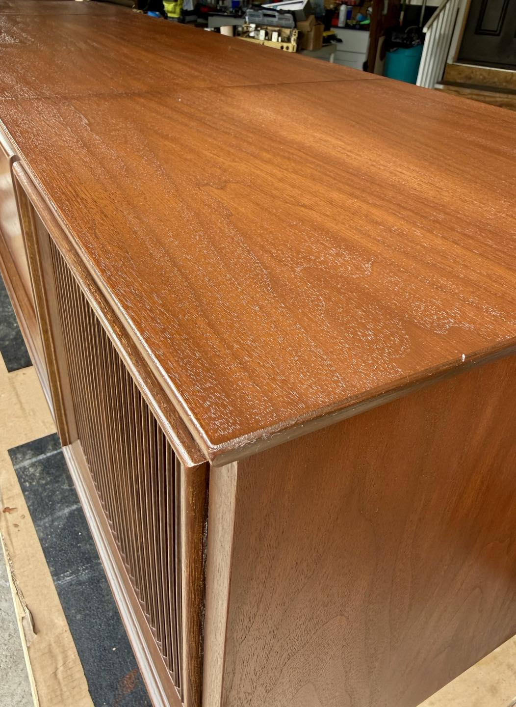 Wooden cabinet with a textured surface on a checkered floor